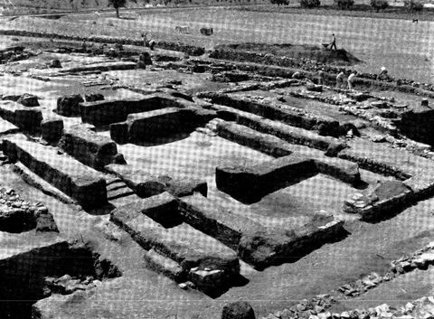 The House of the Tiles at Lerna seen from the northwest, with the plain, trees and some workers behind.