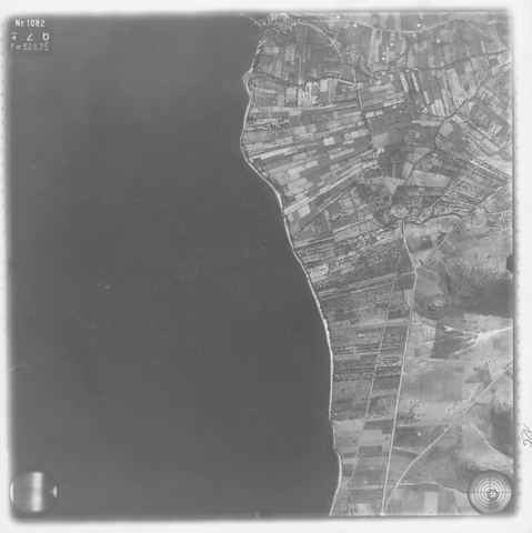 Strip-flight aerial photo of the narrow coastal plain south of Myloi towards Kiveri, with fields and a road.