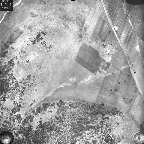 Vertical aerial photo of fields, road and hillside annotated "Turm" (tower).
