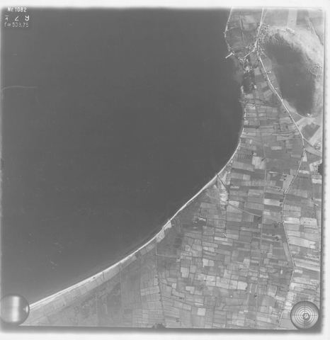 Strip-flight aerial photo of the coast and plain annotated "Myli", with the village at the edge of the frame.