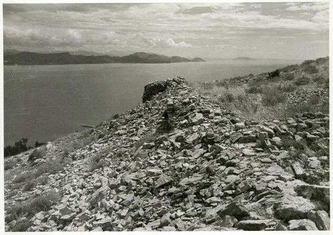 "Kastell Kiveri": rubble of the castle walls with a tower stump and the gulf behind.