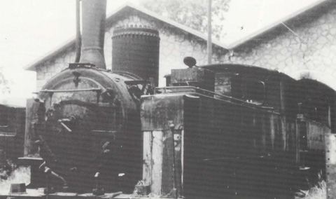Steam locomotive "Ελληνίς" in front of the twin-gabled stone locomotive shed at Myloi.