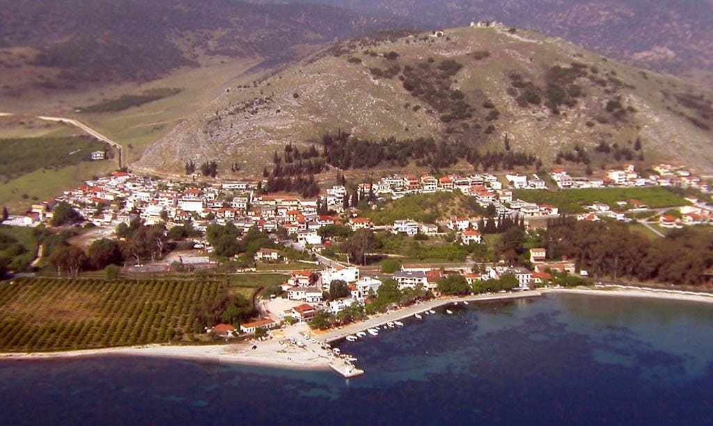 Colour aerial view of the village below Pontinos hill, with the bay, the beach, the pier and orchards