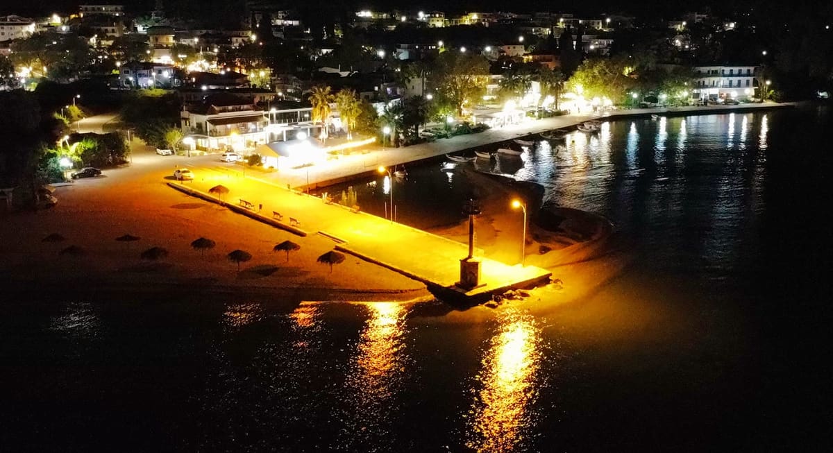 De verlichte pier en boulevard van Myloi 's nachts, van bovenaf gezien