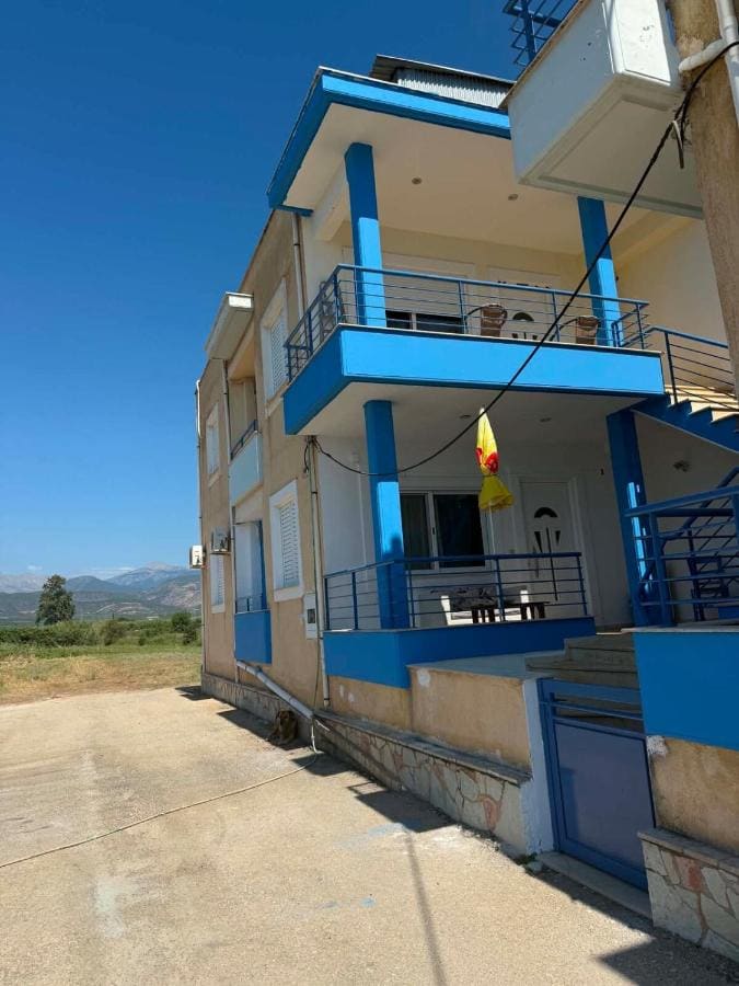 Dom z niebieskimi balustradami i kolumnami balkonów pod czystym błękitnym niebem