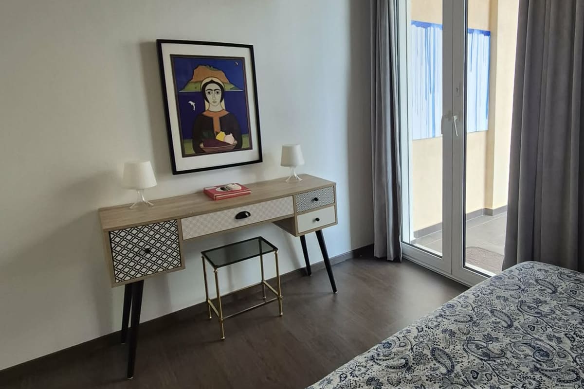 Bedroom corner with a desk and a door to the balcony