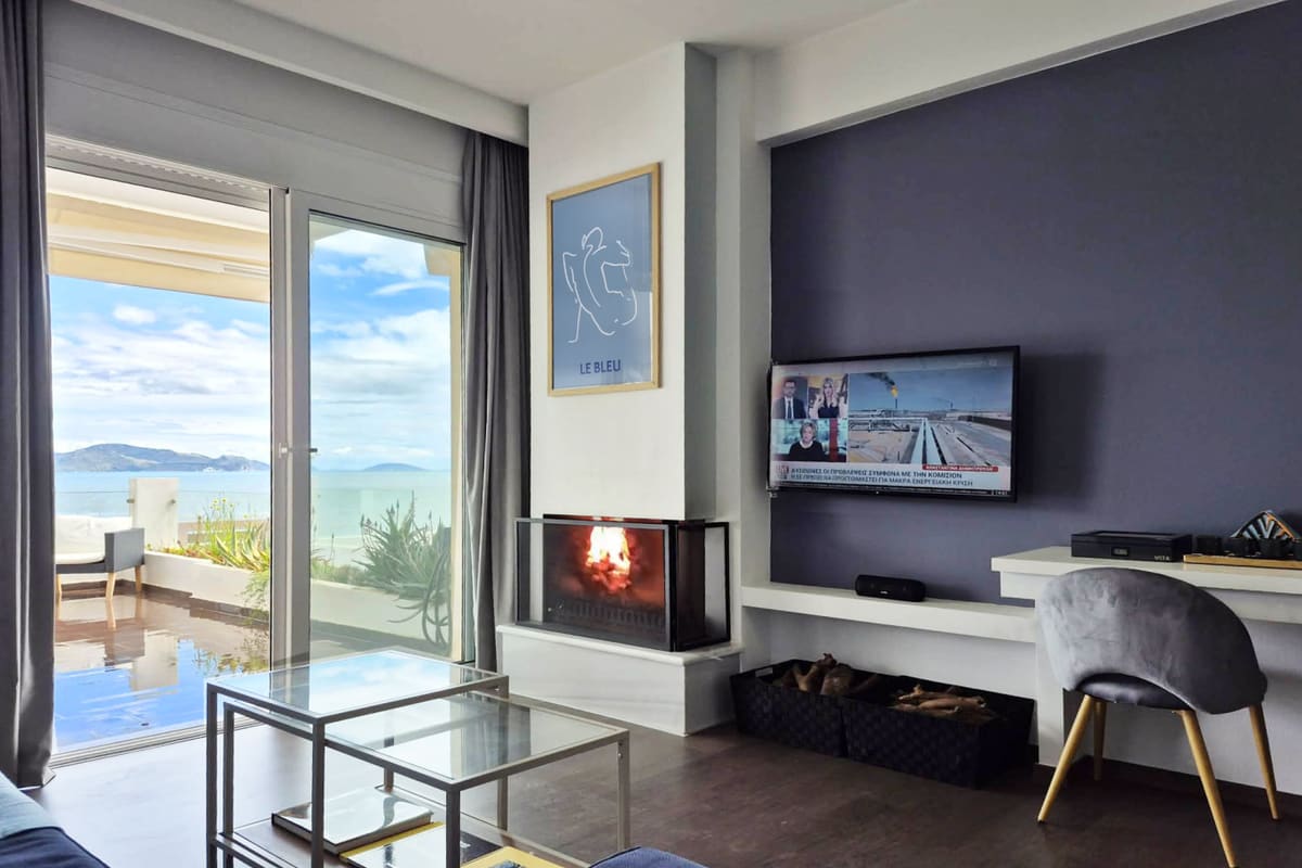 Living room with fireplace and glass doors opening onto a sea view